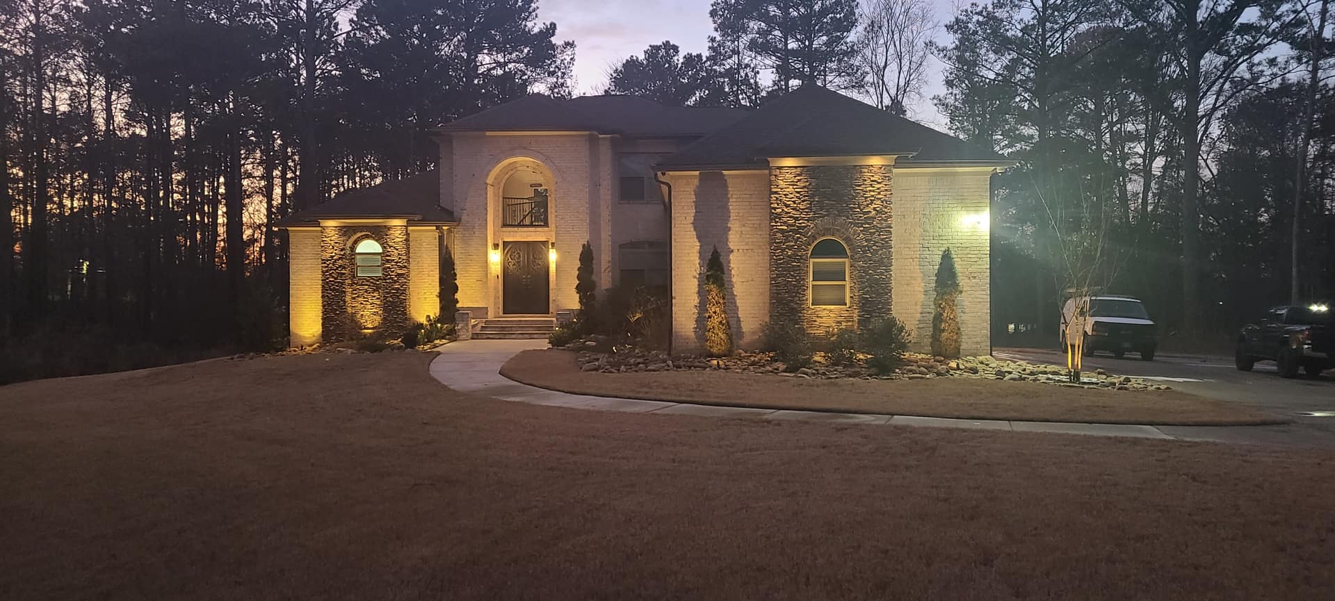 Brick and stone estate dramatically uplit at twilight
