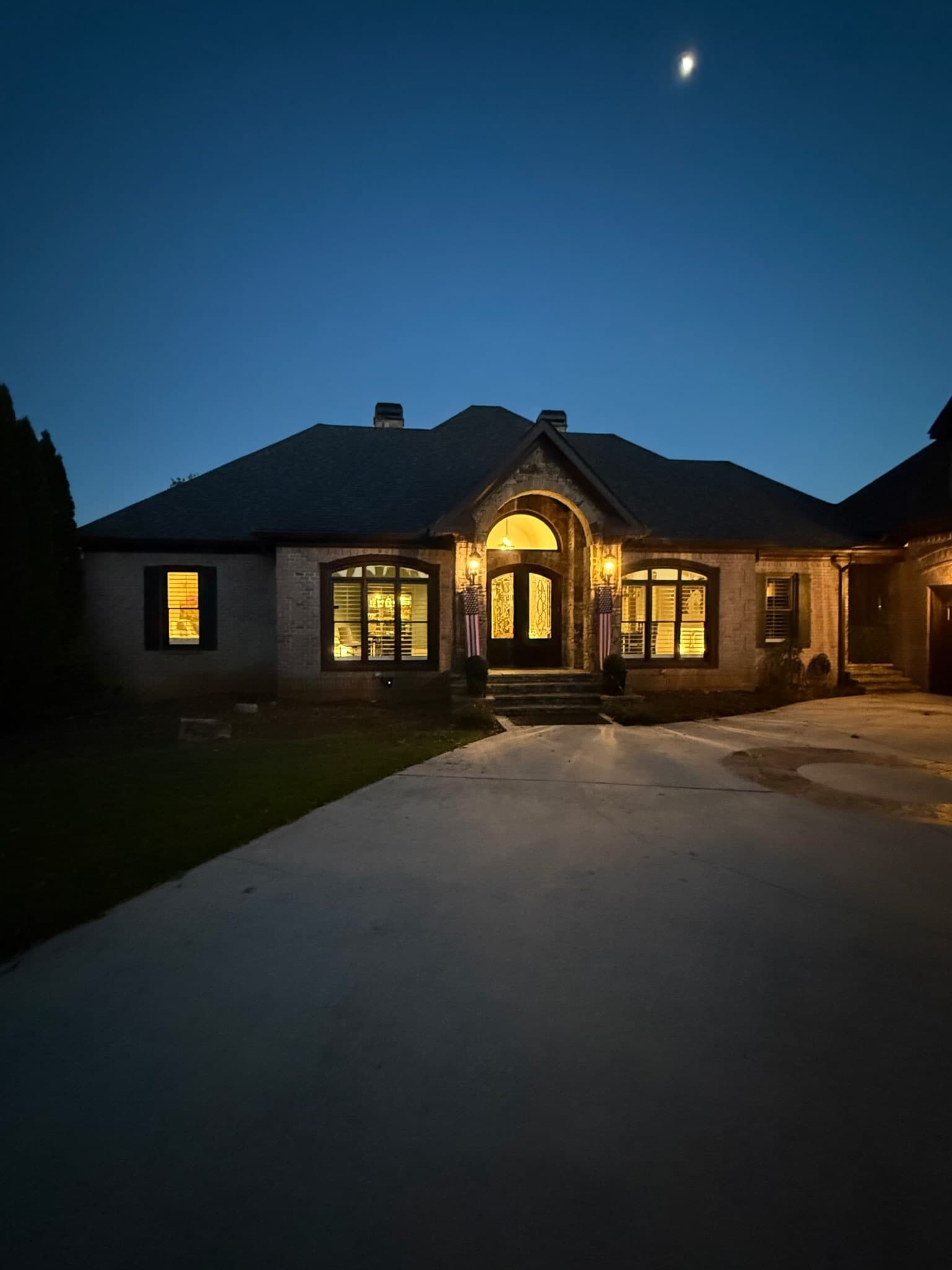 Elegant brick home entrance with tasteful, dark-sky-friendly outdoor lighting in a North Georgia HOA community