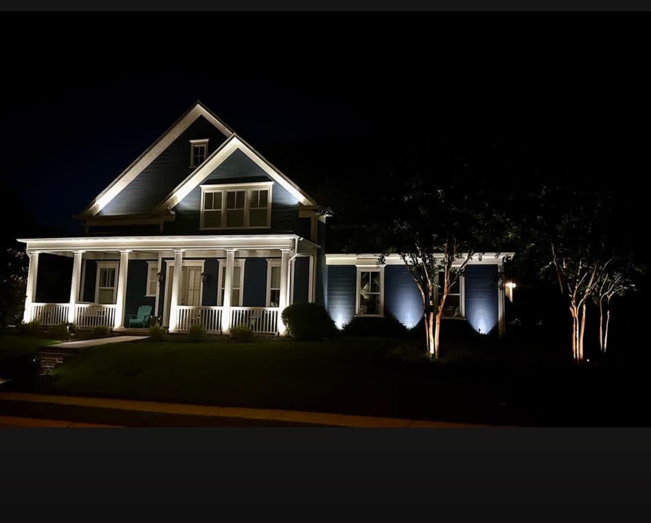 Two-story home in Buford, GA with landscape and facade lighting at dusk